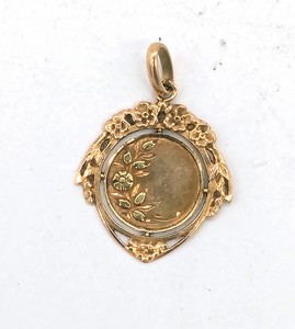 MÉDAILLE en or (750) à décor floral.